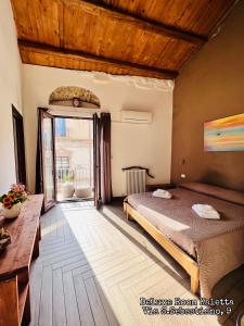 a bedroom with a bed and a wooden ceiling at Kasa Kala Rooms & Apartments in Palermo