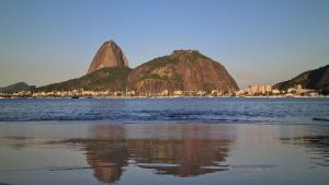 Apto Versátil Praia de Botafogo في ريو دي جانيرو: كمية كبيرة من المياه مع جبلين في الخلفية