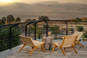 Duas cadeiras e uma mesa num deque com vista em Pereh Mountain Resort em Gadot