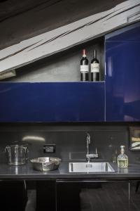 a kitchen with a sink and two bottles of wine at Seven Historical Suites in Trieste