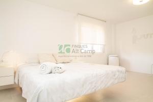 a white bedroom with a bed with towels on it at piso alto standing en Segur de Calafell in Calafell