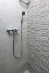 a shower with a shower head in a bathroom at Rijeka Budget Rooms in Rijeka