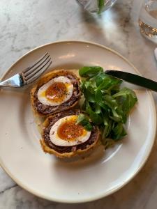 a plate of food with eggs and greens on it at Ballyteige Lodge in Ballyteige Bridge