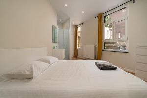 - une chambre blanche avec un grand lit blanc et une fenêtre dans l'établissement Le calme en plein centre ville: Maison 4ch 4sdb, à Liège