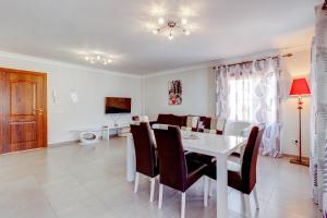 a dining room and living room with a white table and chairs at Cozy two bedroom apartment in San Blas Golf del Sur Tenerife in San Miguel de Abona