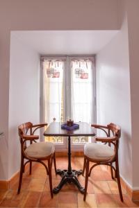 サルラ・ラ・カネダにあるL'Appartement du "Coup de Coeur de Sarlat"の窓のある部屋(テーブル、椅子付)