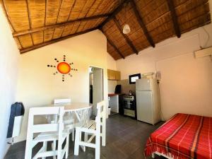 a kitchen with a table and a refrigerator in a room at Cabañas Giramundos in Punta Del Diablo +46 photos