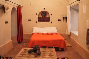 a bedroom with a bed with a red blanket and a window at Riad Diwane in Ouirgane +82 photos