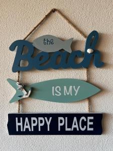 Ein Schild, auf dem steht, dass der Strand mein glücklicher Ort ist. in der Unterkunft Apto novo Imperia Lounge pé-na-areia Itacimirim in Itacimirim