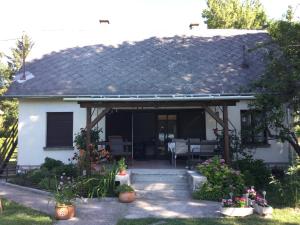 a white house with a roof with a patio at Füge Vendégház Csopak in Csopak