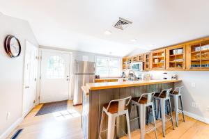 a kitchen with wooden cabinets and a counter with stools at Summer Sliving in Orleans