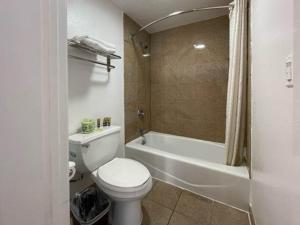 y baño con aseo blanco y bañera. en Motel 6 San Francisco CA Lombard Street en San Francisco
