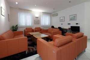 a waiting room with orange chairs and a flat screen tv at Rijeka Budget Rooms in Rijeka
