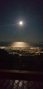 pełnia księżyca nad wodą w nocy w obiekcie CHALET w mieście Patras