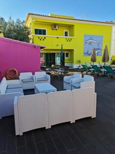 a group of wicker chairs and a yellow building at Villa do Lago in Silves