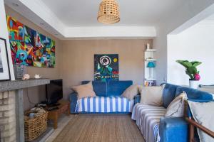a living room with a blue couch and a fireplace at Lisbon Waves Surf Lodge in Costa da Caparica