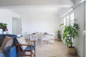 een woonkamer met een blauwe bank en een tafel bij Lisbon Waves Surf Lodge in Costa da Caparica