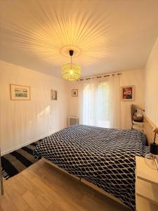 een slaapkamer met een groot bed en een kroonluchter bij 2TERIMP03 Superbe T2 neuf rez de chaussée avec 1 chambre et terrasse in Collioure
