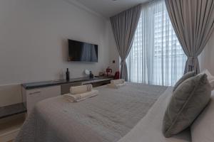 een grote slaapkamer met een groot bed en een televisie bij Sky & Sun Luxury Rooms with private parking in the garage in Zadar