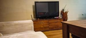 a living room with a television on a wooden dresser at Pirin Place Bansko in Bansko