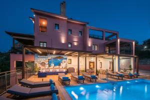 een huis met een zwembad ervoor bij Villa Greco in Chersonissos