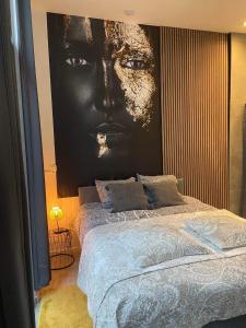 een slaapkamer met een grote foto van een gezicht aan de muur bij Garden Suite in city center in Antwerpen