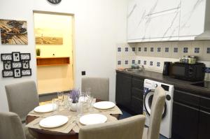Un comedor con una mesa y una cocina. en City center Two room Apartment with One Bedroom, up to 5 Guests, SELF CHECK-IN, FREE parking, en Riga