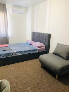 uma cama e uma cadeira num quarto em Apartment on Zarwanska Street em Kamianets-Podilskyi