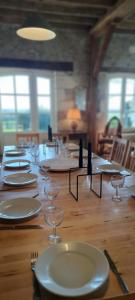 une longue table en bois avec des assiettes et des verres dans l'établissement LA PINÇONNIERE, à Verneuil-sur-Indre