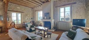 Una sala de estar con un sofá y una chimenea. en LA PINÇONNIERE, en Verneuil-sur-Indre