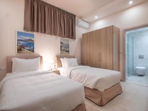 een slaapkamer met 2 bedden en een badkamer bij Villa Greco in Chersonissos +46 foto's