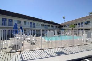 un edificio con piscina con sillas y parque infantil en Motel 6-Indio, CA - Palm Springs en Indio