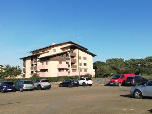 duży budynek z samochodami zaparkowanymi na parkingu w obiekcie sweet-home w mieście Seignosse