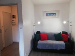 kanapa z czerwonymi i zielonymi poduszkami w pokoju w obiekcie sweet-home w mieście Seignosse