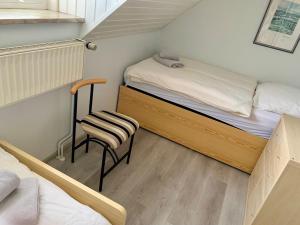 a small bedroom with a bed and a chair at Leuchtturmblick Ferienhaus in Dangast