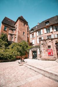 L'Appartement du "Coup de Coeur de Sarlat" في سارلا لا كانيدا: شخصان يجلسون على الدرج أمام مبنى قديم