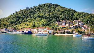 a group of boats docked in a body of water at Excelente casa em Angra dos Reis condomínio com praia e piscina. in Angra dos Reis