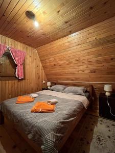 ein Schlafzimmer mit einem Bett in einer Holzhütte in der Unterkunft Golija Vikendica Česta Vrela in Raška