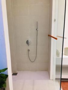 a shower with a hose in a bathroom at Saffron Robes Living in Hikkaduwa