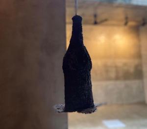a wine bottle hanging from a string in a room at Saffron Robes Living in Hikkaduwa
