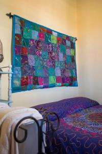 eine Decke, die an der Wand eines Schlafzimmers hängt in der Unterkunft Etnica Penthouse in Mascalucia
