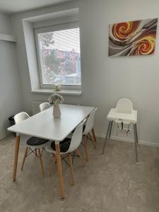 a dining room with a white table and chairs at Apartman Duna in Piešťany