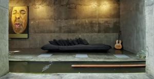 a black couch and a guitar in a room at Saffron Robes Living in Hikkaduwa
