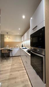 a kitchen with stainless steel appliances and a table at Appartement cosy in Souillac +10 photos