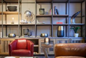 - un salon avec une chaise rouge et des étagères dans l'établissement Bretterbude Büsum, à Büsum
