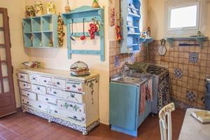 una cucina con armadi blu e lavandino di Etnica Penthouse a Mascalucia