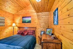 ein Schlafzimmer mit einem Bett in einer Holzhütte in der Unterkunft Cozy Manistique Cabin with Deck, Grill and Fire Pit! in Manistique