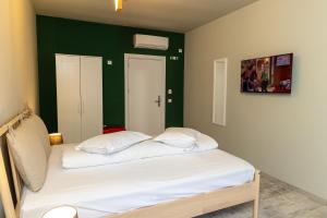 twee bedden in een kamer met een groene muur bij EdMont in Pietroşiţa
