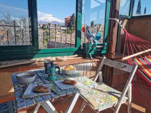 einen Tisch mit Essen drauf mit Bergblick in der Unterkunft Etnica Penthouse in Mascalucia