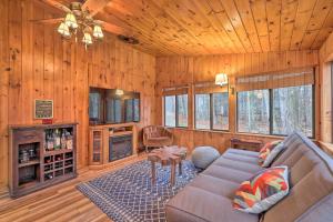 a living room with a couch and wooden walls at Furnished Deck and Fire Pit Lake Wallenpaupack Home in Lake Ariel